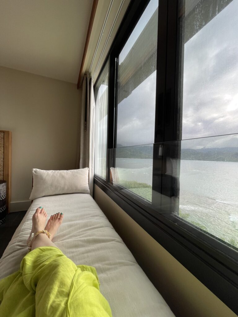 lounging on a window seat bench in room at the 1 hotel Hanalei bay overlooking ocean