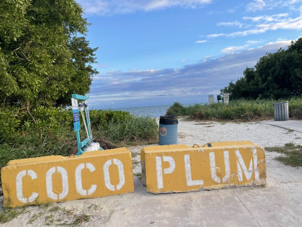 entrance to coco plum beach with the name written on cement blocks